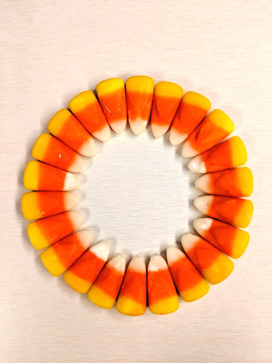 The Candy Corn Flowers arranged in a unique circle on a white surface, perfect for fall decor. Brand: Frost Bites - Freeze Dried Goodies.